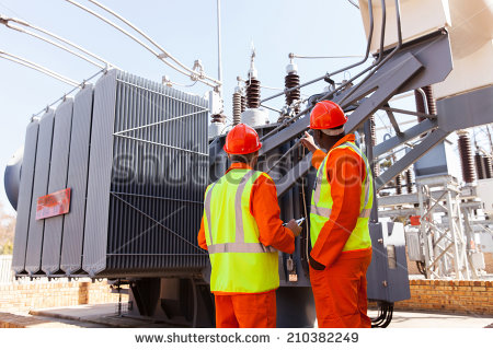 stock-photo-back-view-of-electricians-standing-next-to-a-transformer-in-electrical-power-plant-210382249
